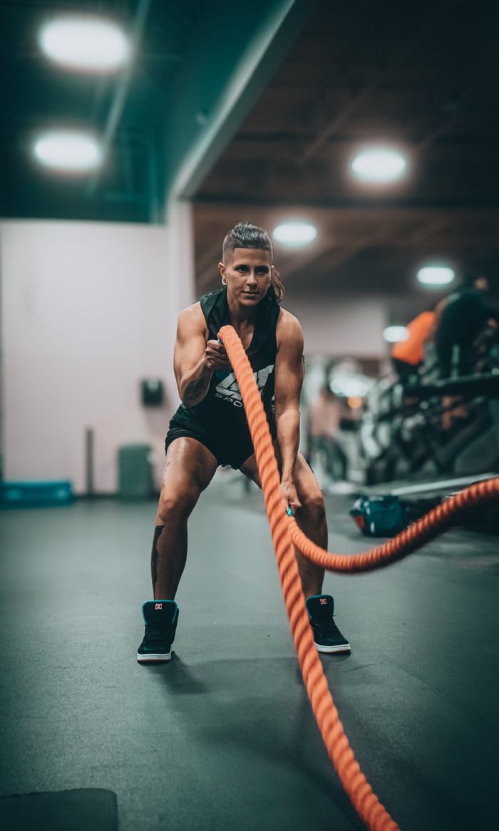 Crafting Captivating Headlines: Your awesome post title goes here Athletic person performing an intense battle rope exercise in a modern gym setting.